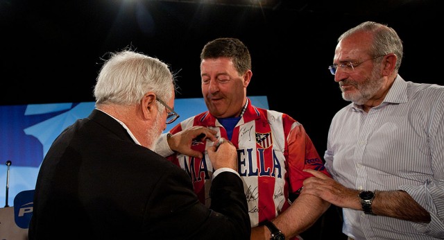 Miguel Arias Cañete firma una camiseta en Las Navas del Marqués, Ávila